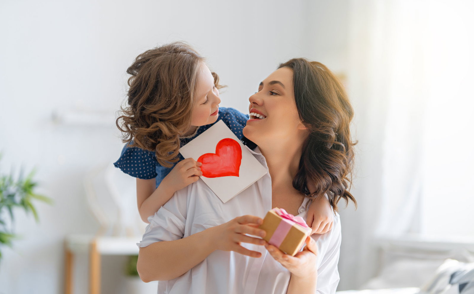 Mutter und Tochter sitzen zusammen am Muttertag und werden beschenkt